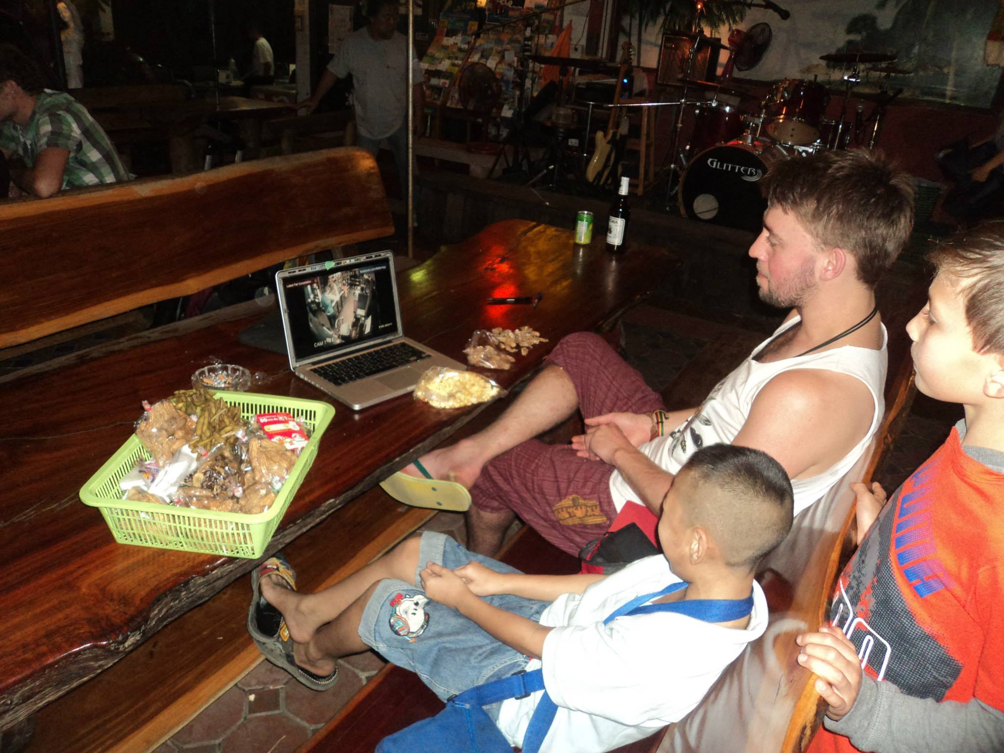 Mike Neumegen and two boys watching a laptop on a table with food